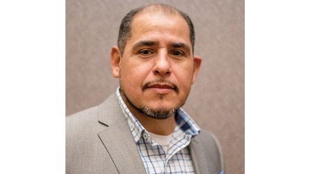 Man with slight smile looks at camera