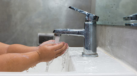Clean kid hands by washing hands with soap