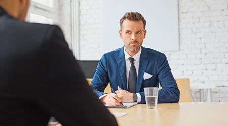 Bearded man in suit interviews a job candidate