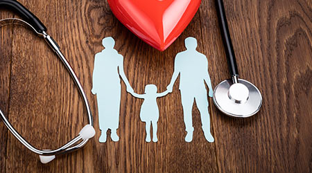 Family holding hands near stethoscope