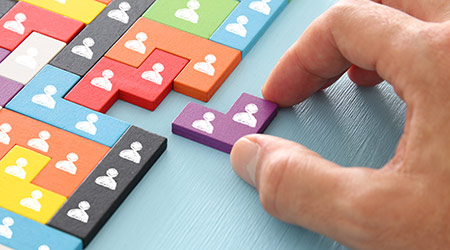 Hand placing final piece of puzzle