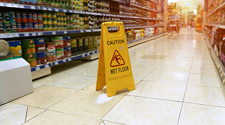 Wet floor sign in grocery store aisle