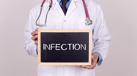 Doctor holding mini blackboard with INFECTION message