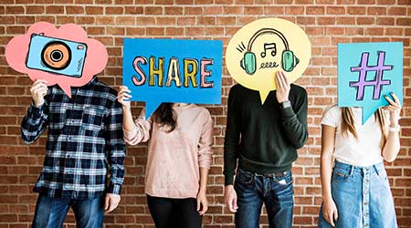 Friends holding up thought bubbles with social media concept icons