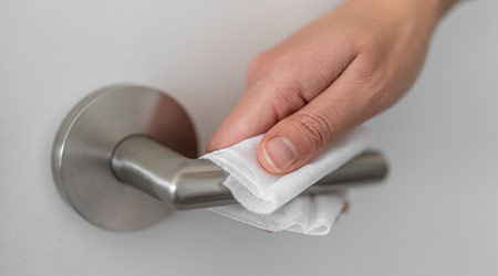 woman wiping door handle