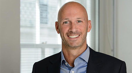 Bald man, possibly of middle age or approaching that age, smiling