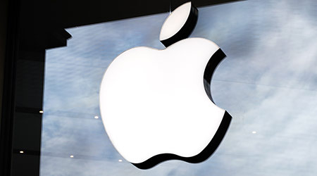 Logo of Apple Inc. on a Apple store. Apple is the multinational technology company headquartered in California and sells consumer electronics products.