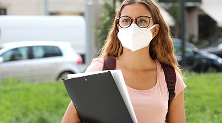 COVID-19 High School student female with protective mask back to school after coronavirus pandemic