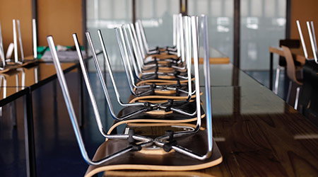 Chairs stacked on desks in classroom