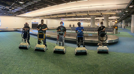 workers pose with carpet cleaners at airport