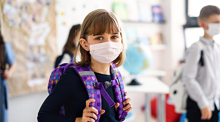 Child with face mask going back to school after covid-19 quarantine and lockdown