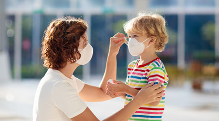 Family with kids in face mask in shopping mall or airport. Mother and child wear facemask during coronavirus and flu outbreak. Virus and illness protection, hand sanitizer in public crowded place.