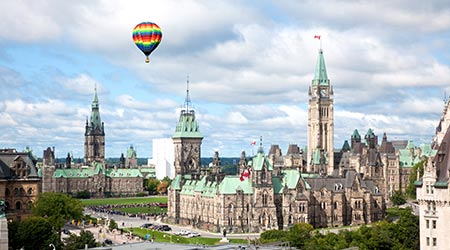 A hot air balloon flies over parliament hill in Canada 