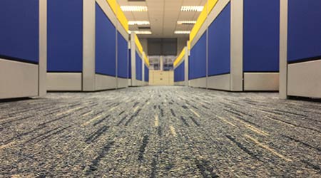 The carpet floor in an office filled with cubicles 