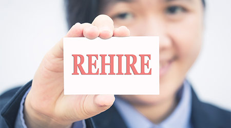 Businesswoman holding card with REHIRE message.
