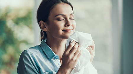 woman smelling cleaning cloth