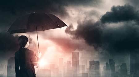Rear view of female entrepreneur holding an umbrella while looking at cloudy sky over the city and standing on the building rooftop