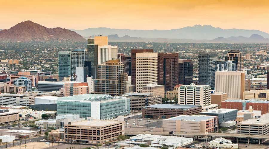 Panoramic aerial view of the Phoenix, Arizona skyline against the day's blue sky.