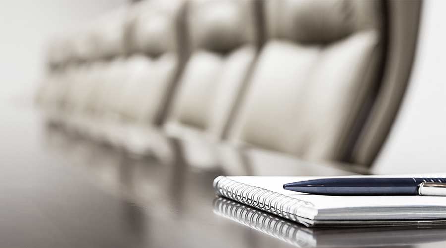 Notepad on table in empty conference room with copy space