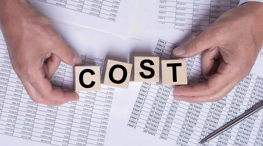cost word on wooden cube blocks on financial documents, top view, male hands
