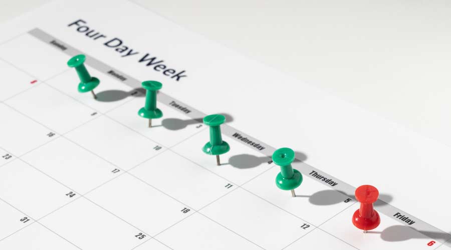 Printed calendar for a 4 day working week showing weekend days in red in new approach to productivity