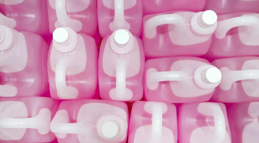 Top view of Professional Liquid Wash Soap Refill light pink color chemicals in plastic bottles cans in the warehouse store. Heap Antibacterial Hand Soap in plastic canisters