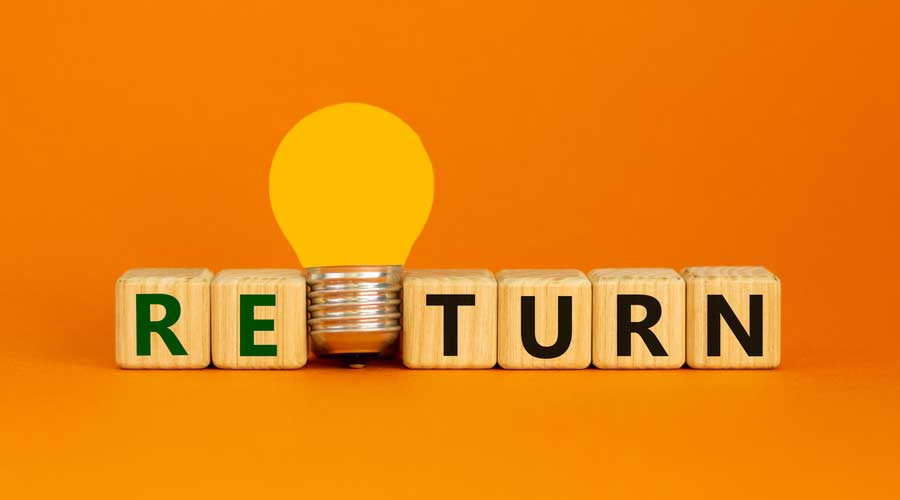 Return symbol. Wooden cubes with word 'return'. Yellow light bulb. Beautiful orange background. Business and return concept. Copy space.