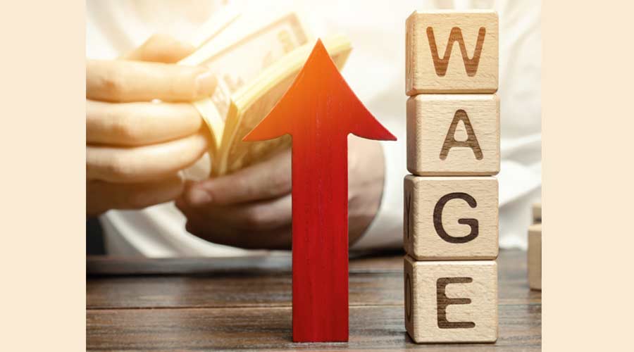 Red arrow up near wooden blocks with the word Wage and a businessman. Salary increase concept. Wages rate. Revenue growth and profits. Successful business. Career rise. Promote. Stability