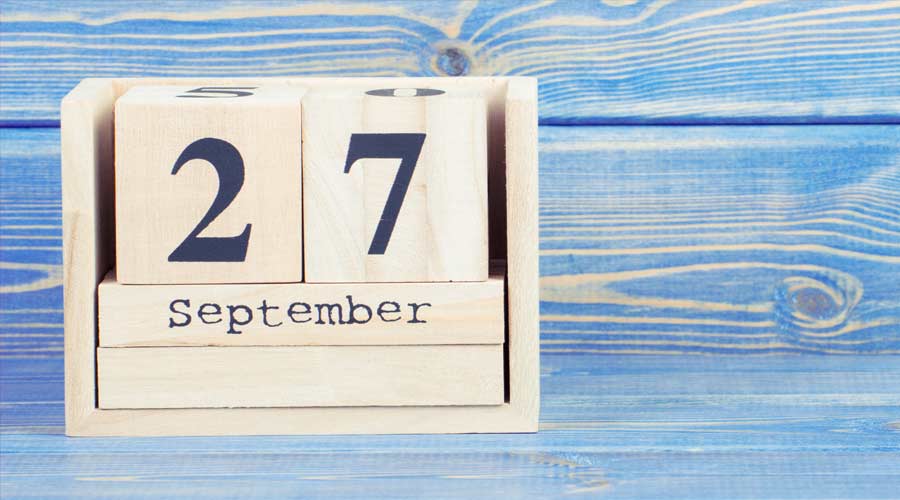 Vintage photo, September 27th. Date of 27 September on wooden cube calendar, copy space for text on board