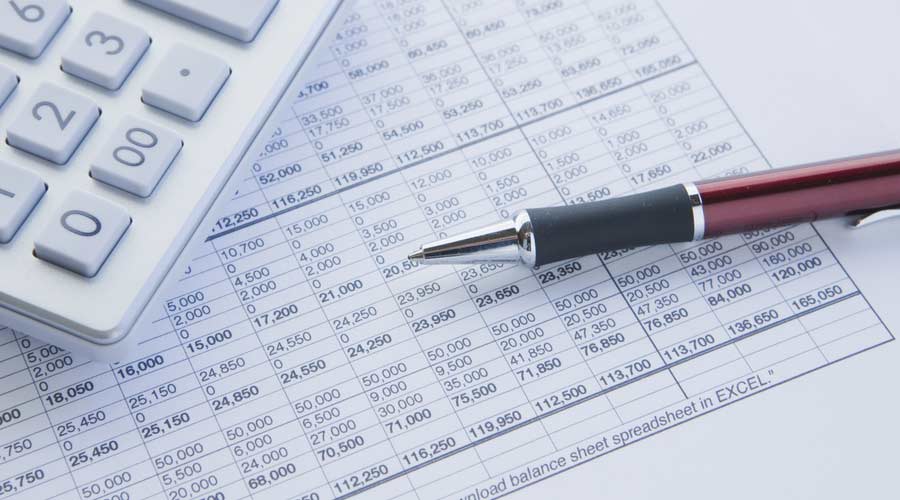 financial balance sheet with calculator and pen