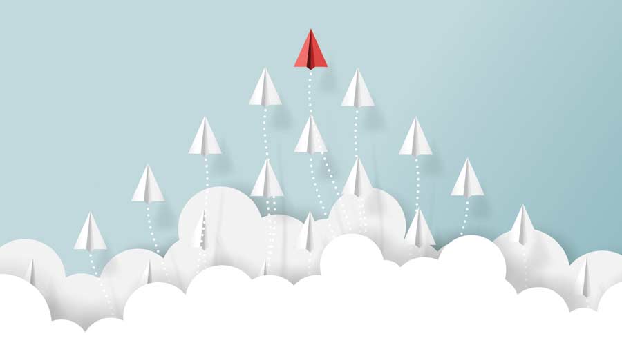 white paper airplanes flying out of the cloud with one red airplane in the lead
