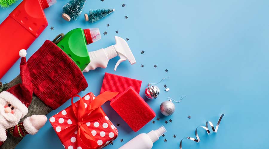 Christmas cleaning. Cleaning tools and Christmas decorations top view flat lay on blue background with copy space