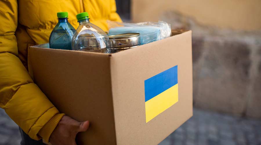Close up of volunteer carrying box with Humanitarian aid for Ukrainian refugees in street