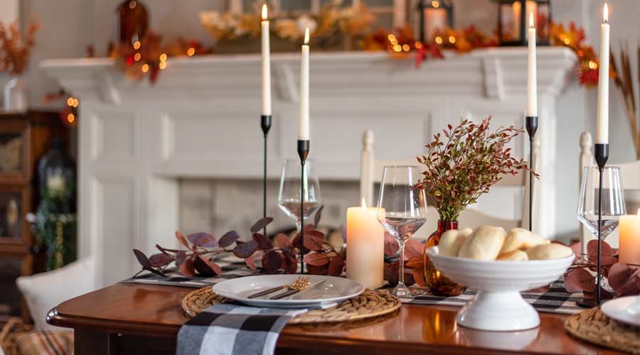 Dinner table decorated for cozy fall holiday gathering
