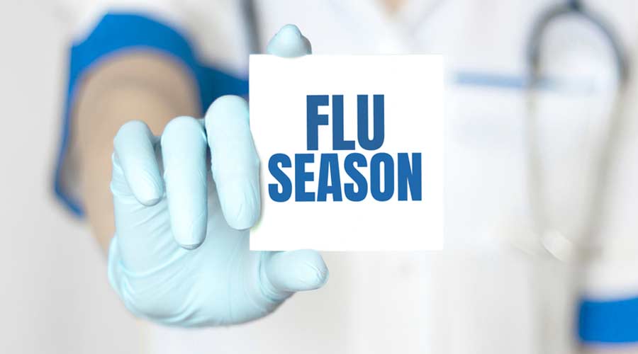 Doctor holding a card with text Flu Season, medical concept