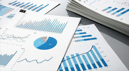 Preparing report. Blue graphs and charts. Business reports and pile of documents on gray reflection background.