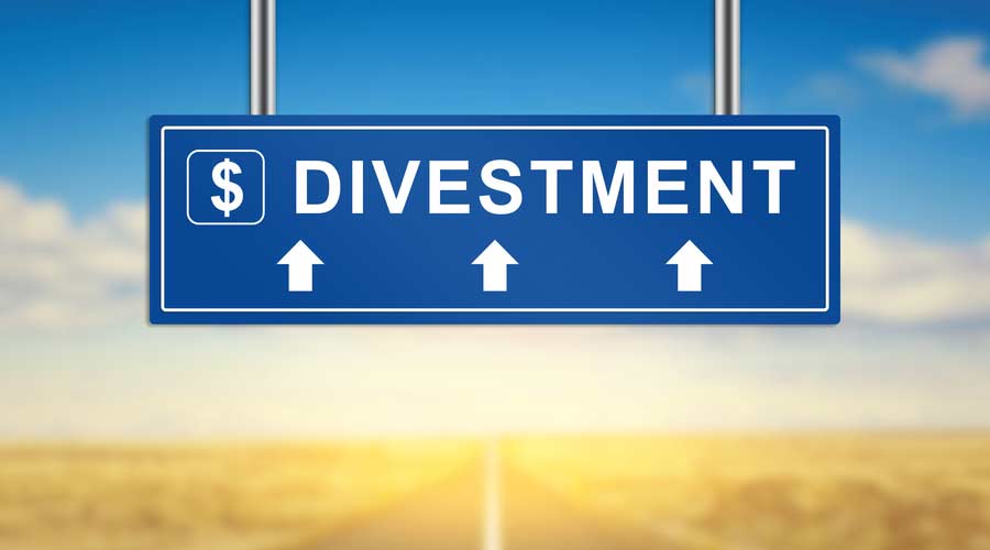 divestment words on blue road sign with blurred background