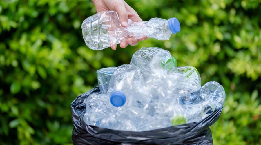 Plastic bottles in black garbage bags waiting to be taken to recycle.