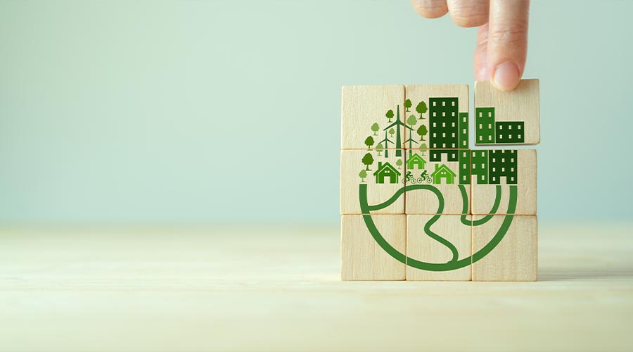 Eco friendly, green company culture concept. Carbon neutral and net zero target. Sustainable enviroment and business. Build green community. Hand holds wooden cubes with eco globe on grey background