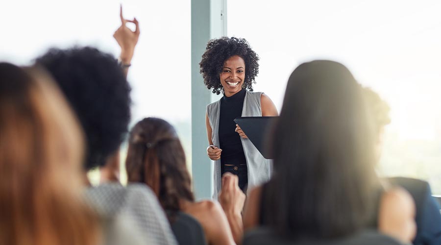 Question, black woman and smile in seminar, speaker and audience in event, training and presentation in boardroom. Workshop, happy and advise for business in conference, entrepreneur and masterclass