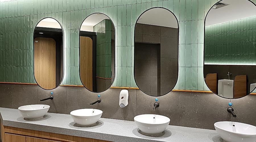 Hand washing facilities with mirror in a public toilet area. Hand washing station in the male restroom