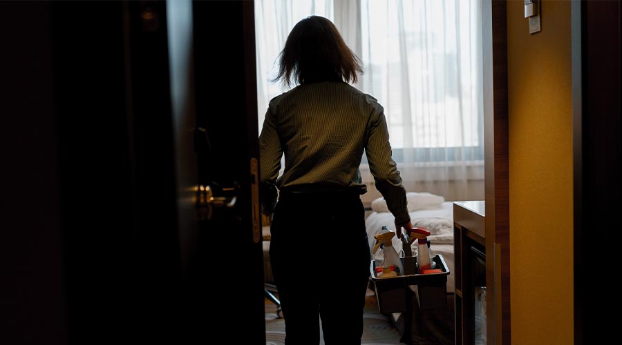 Cleaning rooms in a hotel housekeeper carries basket with detergents concept of cleanliness