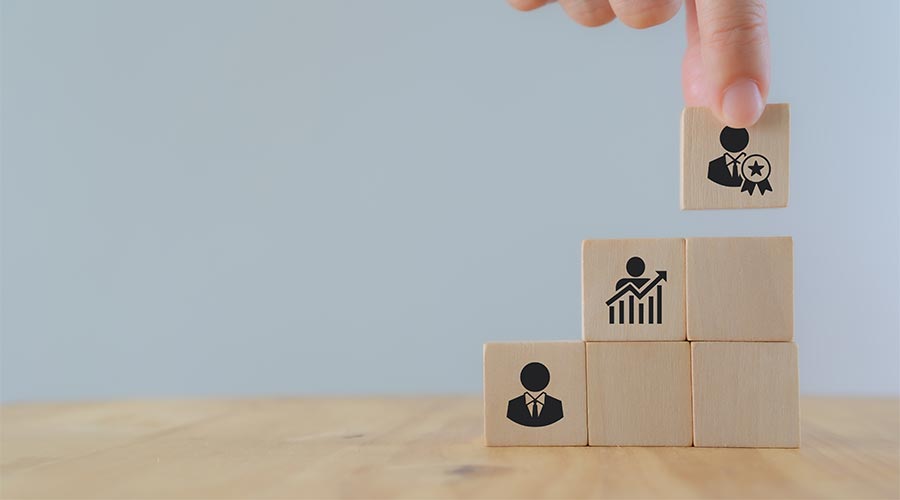Leadership, job promotion, recognition and organizational structure. Wooden blocks representing a personal development, talent management, business leader and job promotion