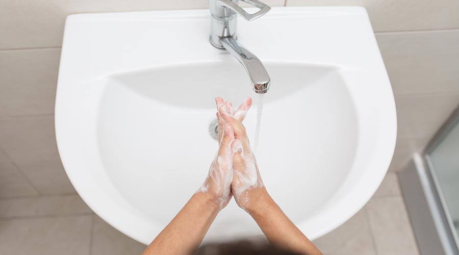 Washing hands in a white sink with soap top view morning hygiene