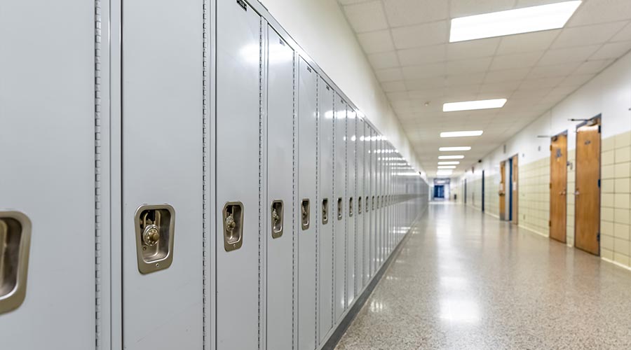 Empty middle school or high school hallway with gray student lockers