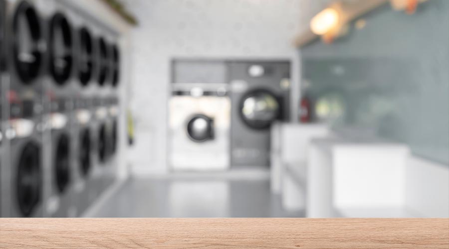 Empty wooden table with blur background of laundry shop.