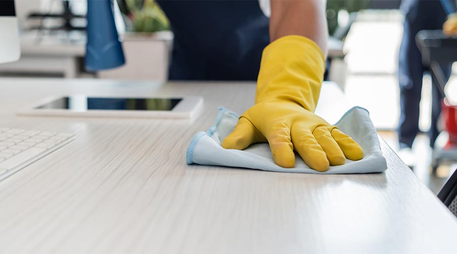 cropped view of office cleaner in rubber gloves