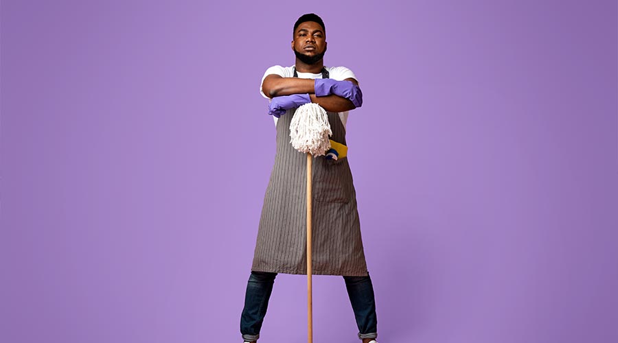 On Guard Of Cleanliness. Professional African American Cleaner Posing With Mop Over Pink Background In Studio, Ready For Big Cleaning
