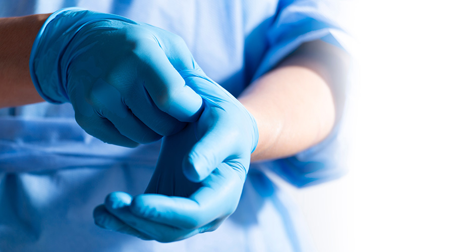 Healthcare Professional Donning Blue Medical Gloves
