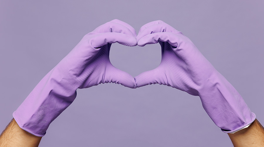 Close up cropped male hold in hand in heart shape gesture while doing housework tidy up isolated on pastel plain light purple color wall background Housekeeping concept. Copy space advertising mock up